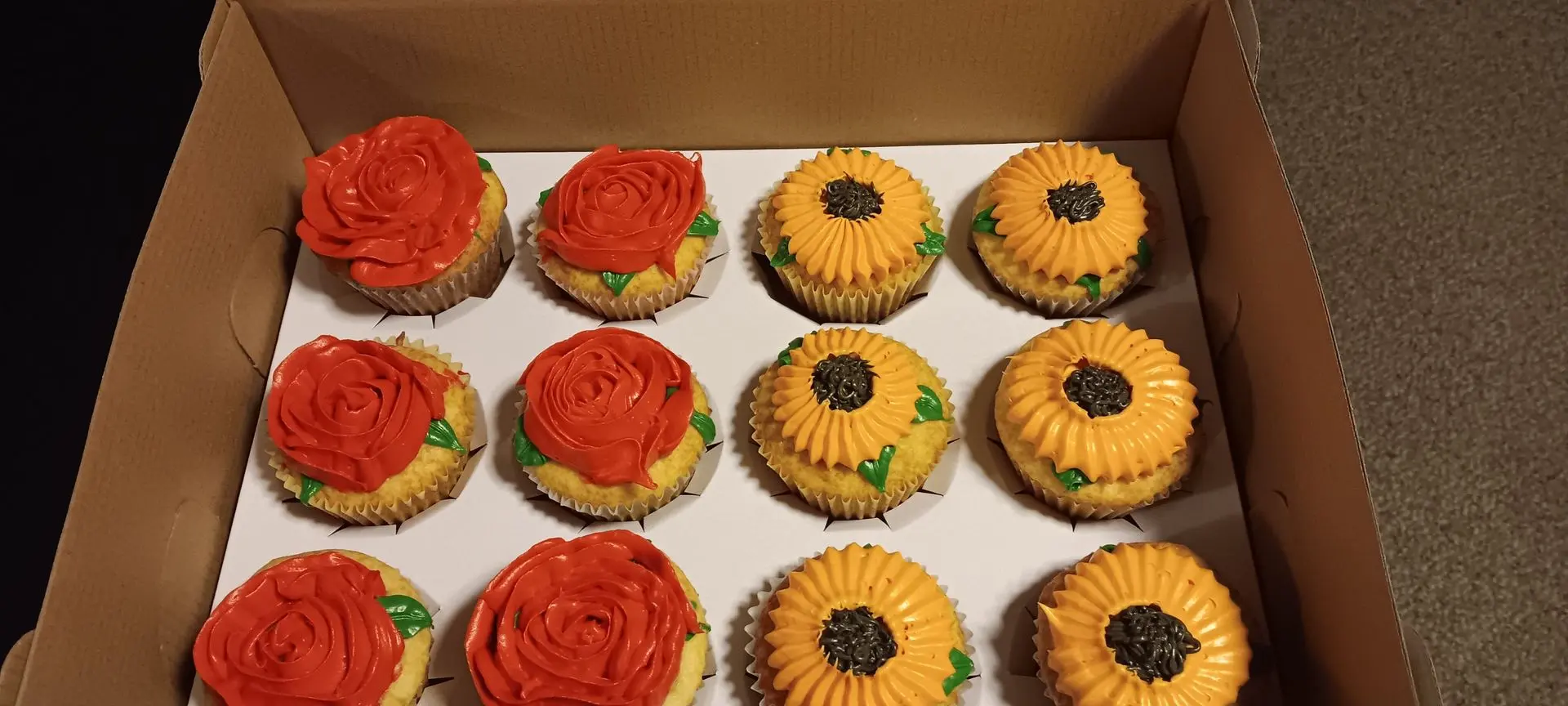 Almond cupcakes with vanilla frosting roses and white frosting sunflowers